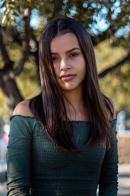 Portrait d'une belle jeune femme portant le haut de l'épaule alors qu'elle se tient à l'extérieur