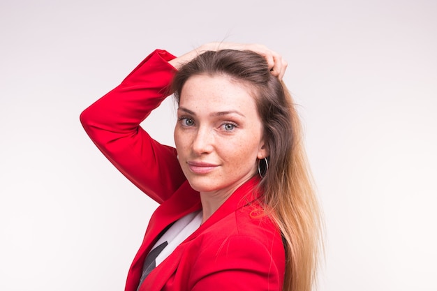 Portrait de la belle jeune femme posant en costume rouge avec la main au-dessus.