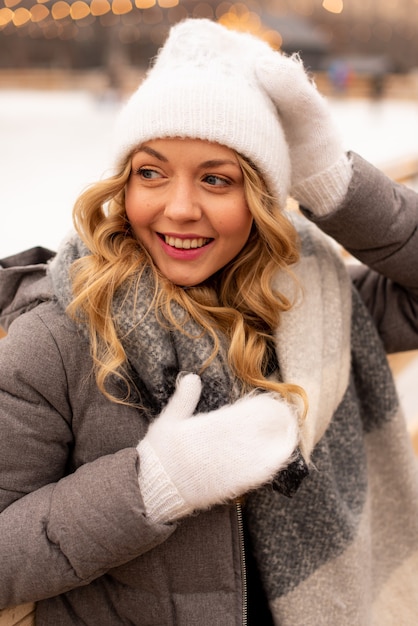 Portrait de la belle jeune femme sur le rang de glace de Noël festif. Dame portant des vêtements tricotés chauds d'hiver.