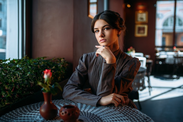 Portrait de la belle jeune femme rétro au café