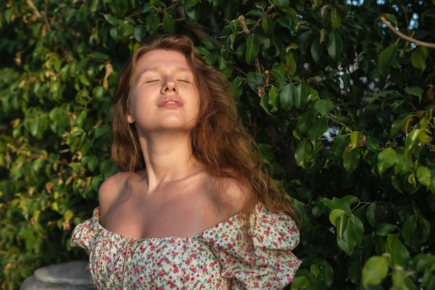 Portrait d'une belle jeune femme en robe profite de l'été ou du printemps sur le vert naturel naturel