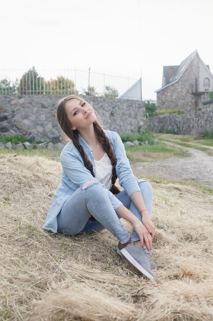 Portrait d'une belle jeune femme romantique à la campagne au coucher du soleil. jolie fille dans des vêtements en jean