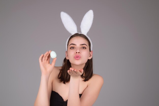 Portrait de belle jeune femme romantique dans des oreilles de lapin célébrant le fond de studio de vacances de pâques