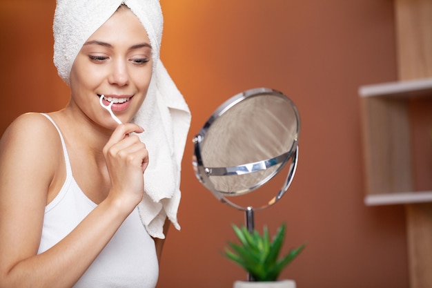 Portrait de la belle jeune femme se brosser les dents