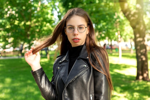 Portrait d'une belle jeune femme séduisante dans des verres dans un bel été vert ou un parc de printemps