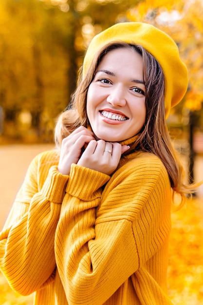 Portrait d'une belle jeune femme souriant à la caméra Un pull dans un pull jaune et un béret