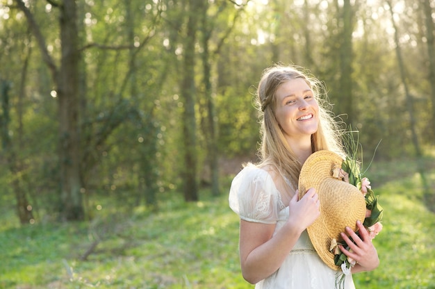 Portrait d&#39;une belle jeune femme souriante avec chapeau en plein air