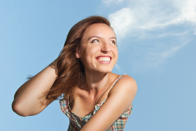 Portrait d'une belle jeune femme souriante contre le ciel - Extérieur