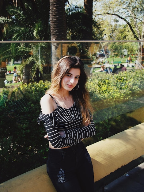 Portrait d'une belle jeune femme souriante debout contre des plantes