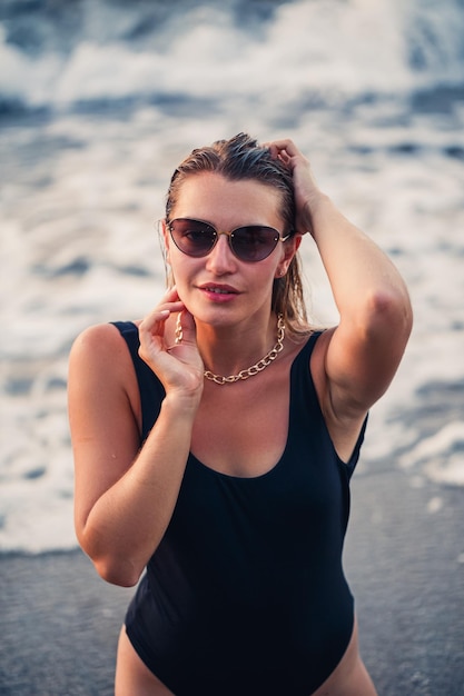 Portrait d'une belle jeune femme souriante profitant de la brise sur la plage