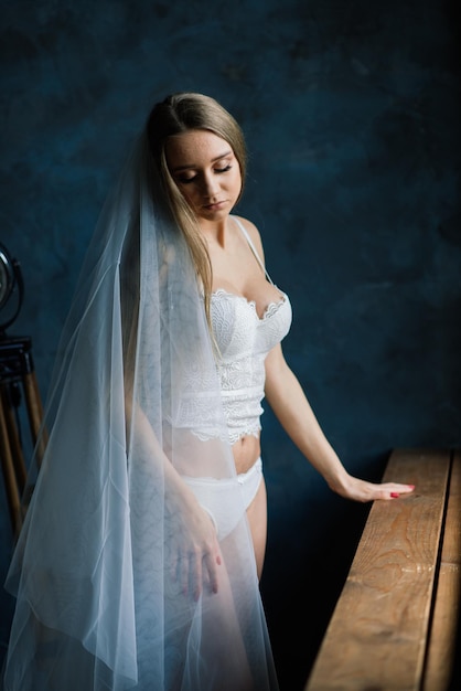 Portrait d'une belle jeune femme en sous-vêtements blancs. Matin de la mariée.