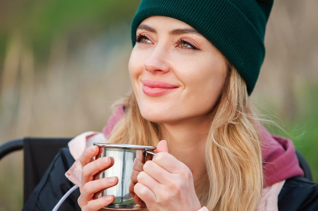 Photo portrait d'une belle jeune femme avec une tasse de thé à l'extérieur