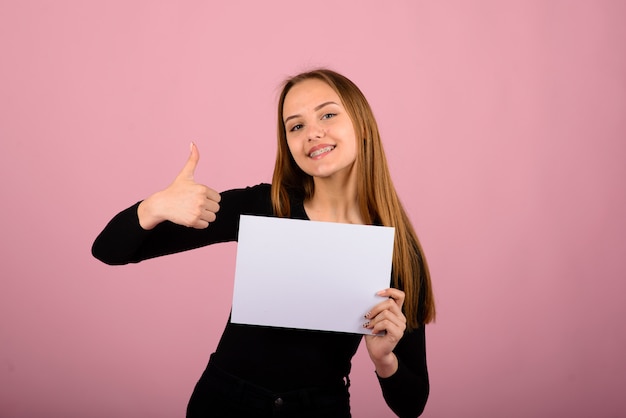 Portrait de la belle jeune femme avec des téléphones et une feuille de papier vierge.