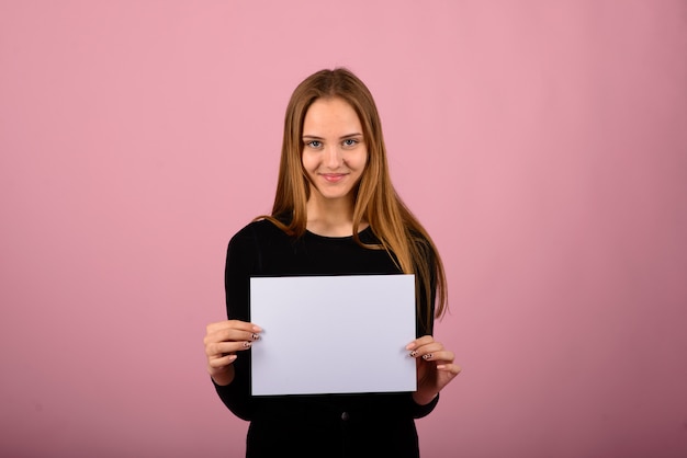 Portrait de la belle jeune femme avec des téléphones et une feuille de papier vierge.