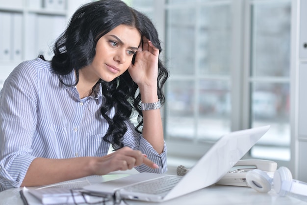 Portrait d'une belle jeune femme travaillant au bureau