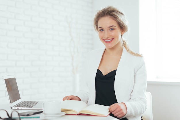 Portrait de la belle jeune femme travaillant au bureau.