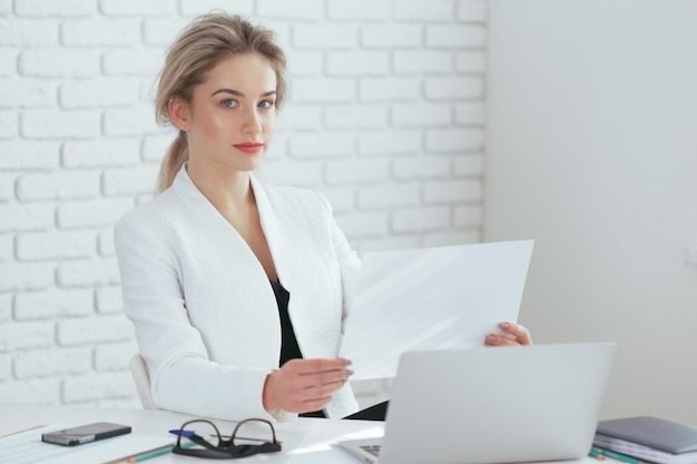 Portrait de la belle jeune femme travaillant au bureau