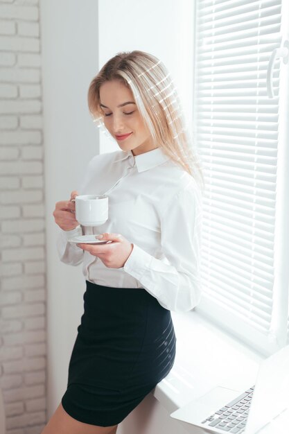 Portrait de la belle jeune femme travaillant au bureau