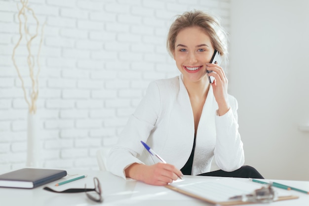 Portrait de la belle jeune femme travaillant au bureau.