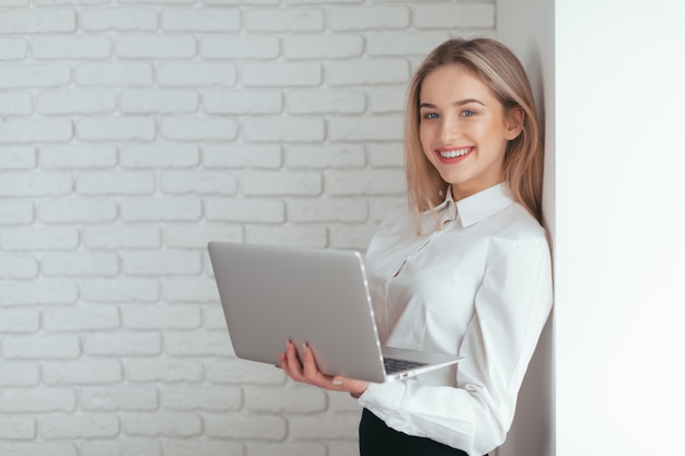 Portrait de la belle jeune femme travaillant au bureau.