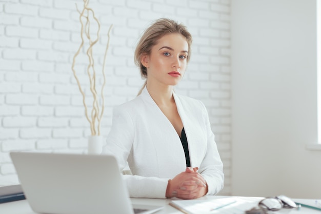 Portrait de la belle jeune femme travaillant au bureau.