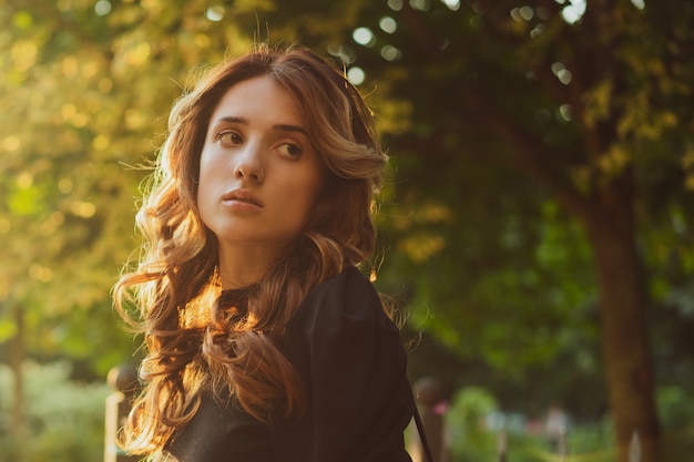 Portrait d'une belle jeune femme triste au coucher du soleil au soleil