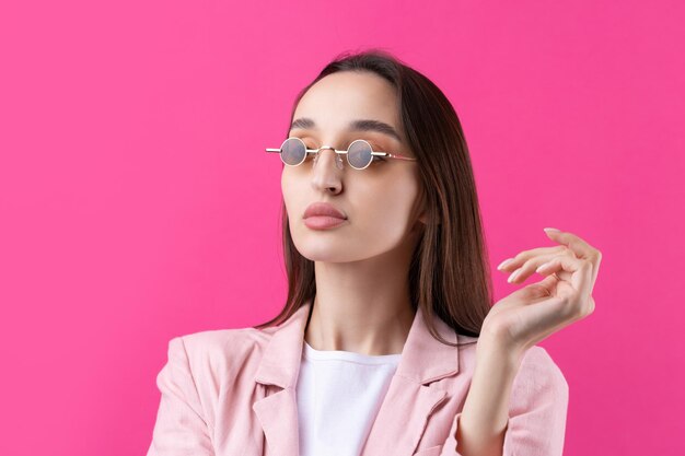 Portrait de la belle jeune femme en veste rose pensant isolé sur fond rouge