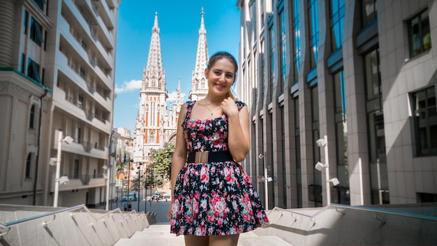 Portrait d'une belle jeune femme visitant la vieille ville européenne avec l'ancienne cathédrale