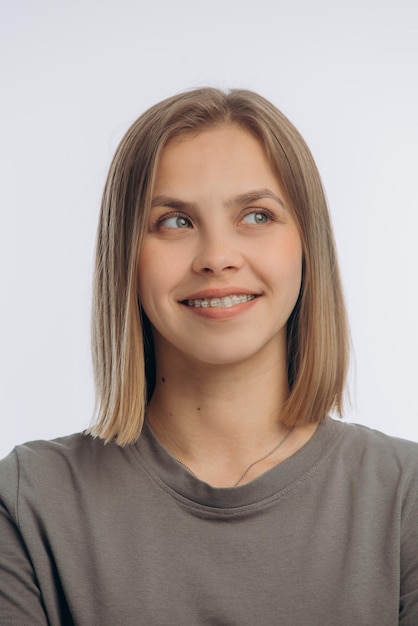 Portrait d'une belle jeune fille à bretelles sur fond blanc