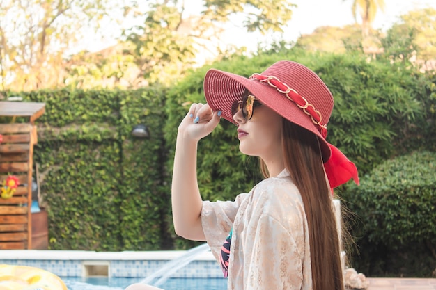 Portrait d'une belle jeune fille avec chapeau rouge et lunettes de soleil.