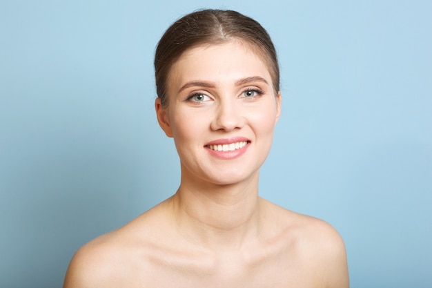 Portrait d'une belle jeune fille avec du maquillage nude sur fond coloré