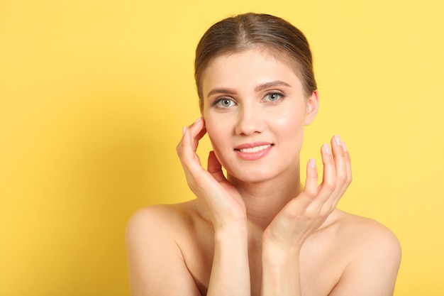 Portrait d'une belle jeune fille avec du maquillage nude sur fond coloré