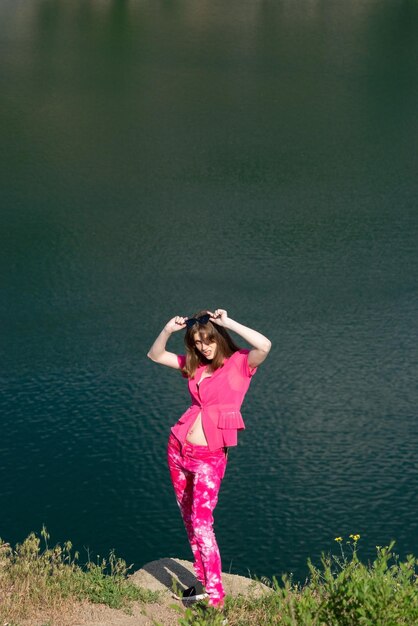 Portrait d'une belle jeune fille à la mode dans la génération rose z Dans le contexte de l'eau du lac