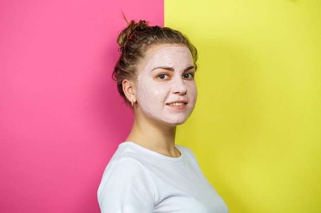 Portrait d'une belle jeune fille qui met un masque rafraîchissant sur son visage pour rajeunir et tonifier la peau. Soins de beauté