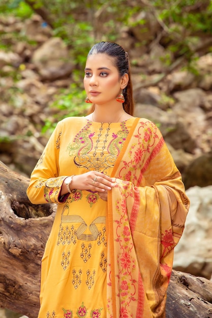 Portrait de belle jeune fille vêtue d'une robe traditionnelle jaune pour une séance photo de mode dans la nature