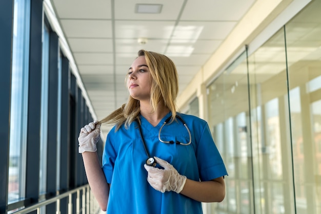 Portrait de la belle jeune infirmière en inofrm bleu en clinique. soins de santé