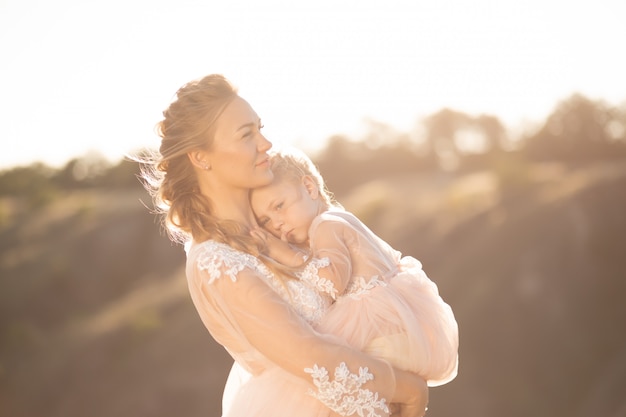 Portrait d'une belle jeune maman tient sa fille bien-aimée dans ses bras. Amour parental, petite princesse