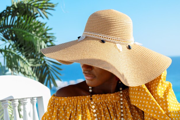 Photo portrait d'une belle mannequin afro-américaine dans un chapeau de soleil élégant femme noire à la mode sur naturel