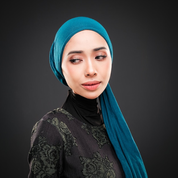 Portrait d'une belle mannequin musulmane portant des vêtements décontractés modernes avec hijab isolé sur noir