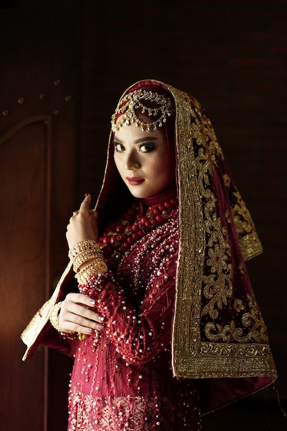 Portrait d'une belle mariée indienne en robe or et rouge