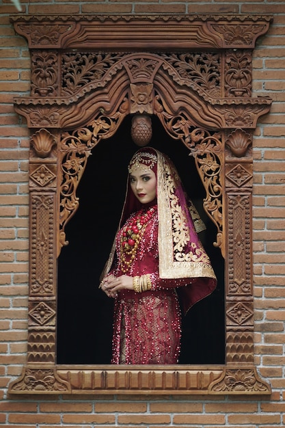 Portrait d'une belle mariée indienne en robe or et rouge