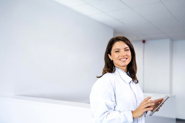 Portrait d'une belle médecin souriante debout dans le hall de l'hôpital