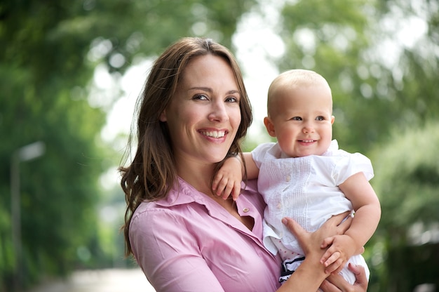 Portrait d&#39;une belle mère avec bébé souriant en plein air