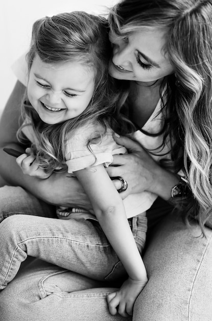 Portrait de belle mère joyeuse avec sa fille mignonne s&#39;amuser ensemble à la maison. Sourire petite fille avec maman