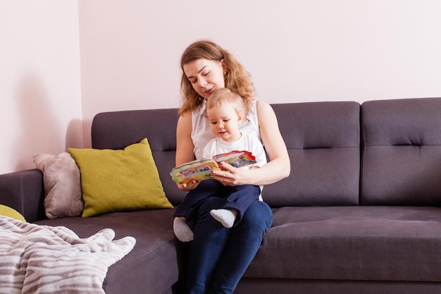 Portrait d'une belle mère souriante lisant un livre à son petit garçon