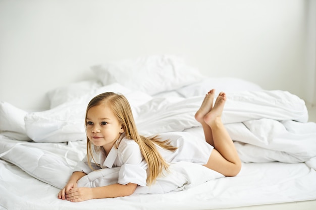 Un portrait de belle petite fille dans la chambre à coucher du matin