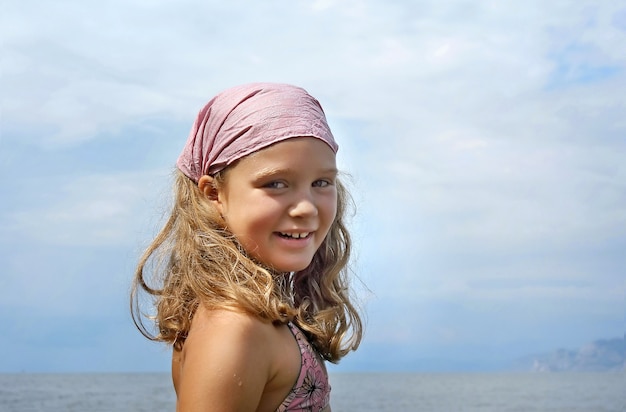 Portrait de belle petite fille sur fond de mer, scène d'été.