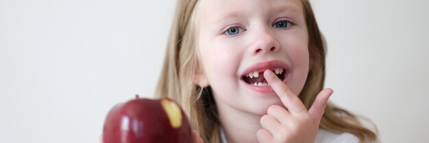 Portrait d'une belle petite fille sans dents avec pomme
