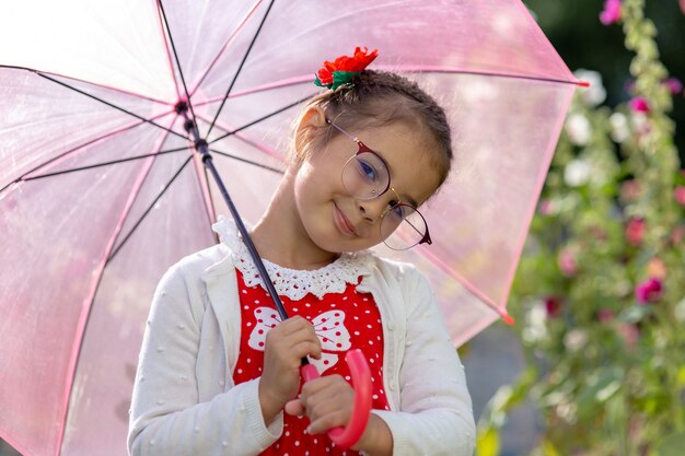 Portrait d'une belle petite fille souriante avec parapluie