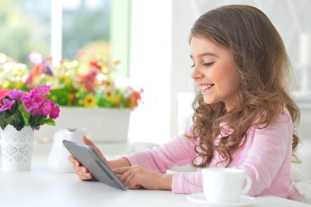 Portrait de belle petite fille avec tablet pc